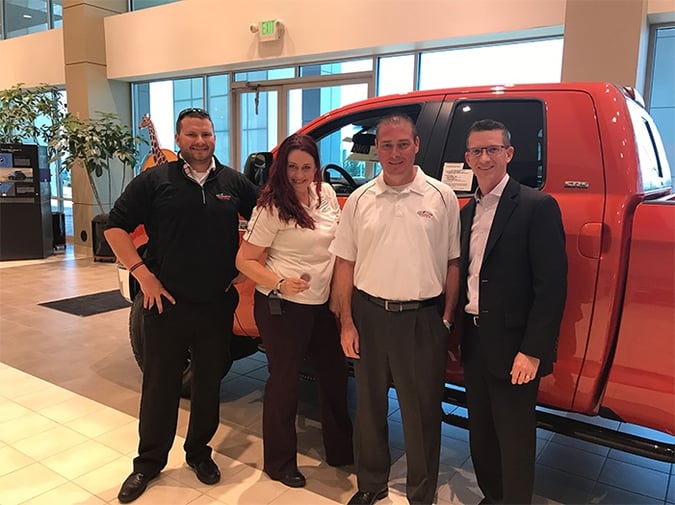 Sales Representative Christian Janzen, far left, Sales Representative Jen Decker, holding the coin, and General Sales Manager Sean Kramer, third from left, proudly accept the Insignia challenge coin from Insignia President David Stringer, April 12, at Mountain States Toyota, in Denver, CO.