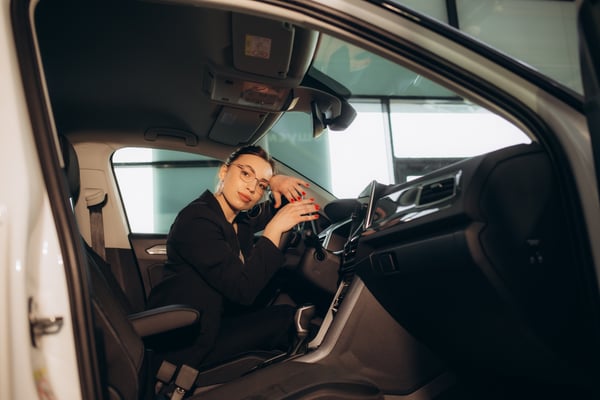 a-woman-in-the-middle-of-a-car-in-a-car-dealership-2024-04-05-19-49-20-utc