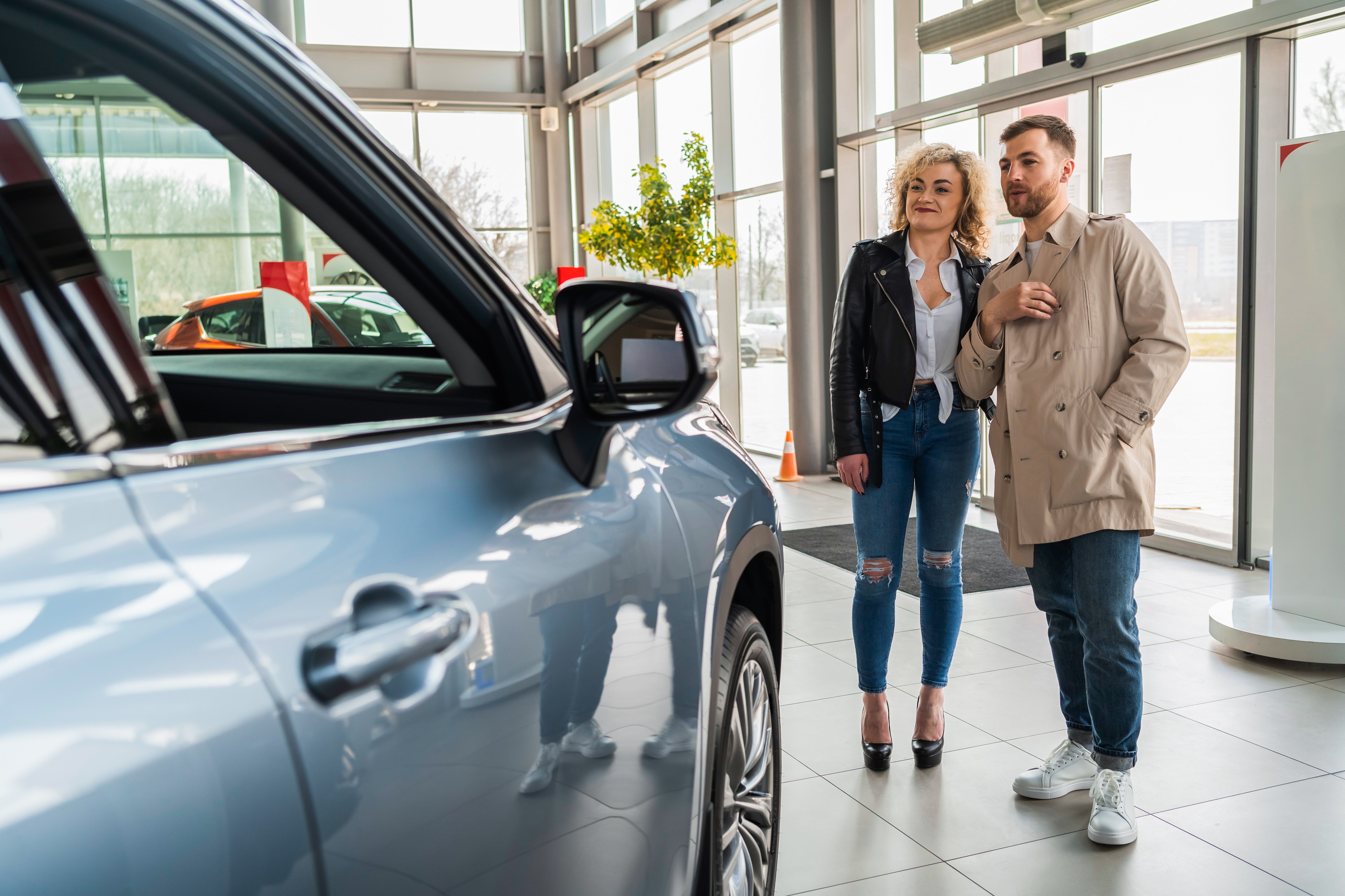 beautiful-couple-in-car-dealership-chooses-car-2022-02-02-22-05-45-utc