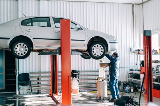 car-lifted-on-car-lift-for-routine-maintenance-F5DB9EQ