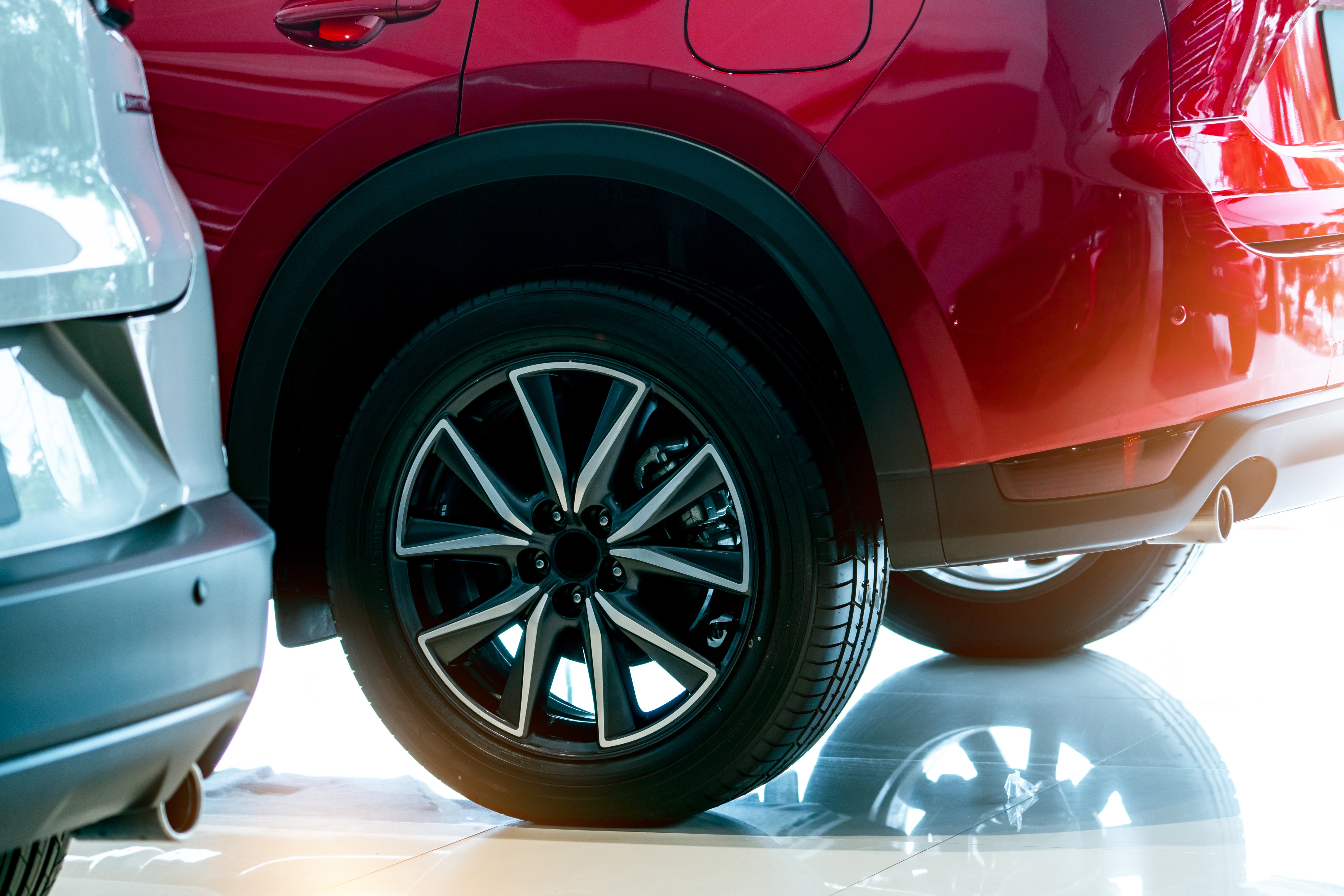 closeup-wheel-of-red-car-parked-in-showroom-wheel-2022-10-25-10-04-43-utc