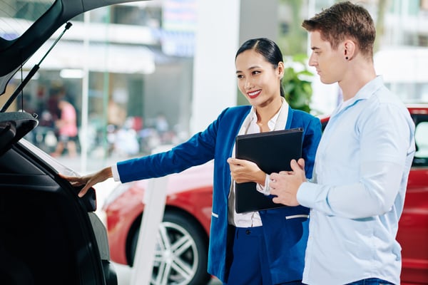 dealership-manager-opening-car-trunk-2023-11-27-05-36-37-utc