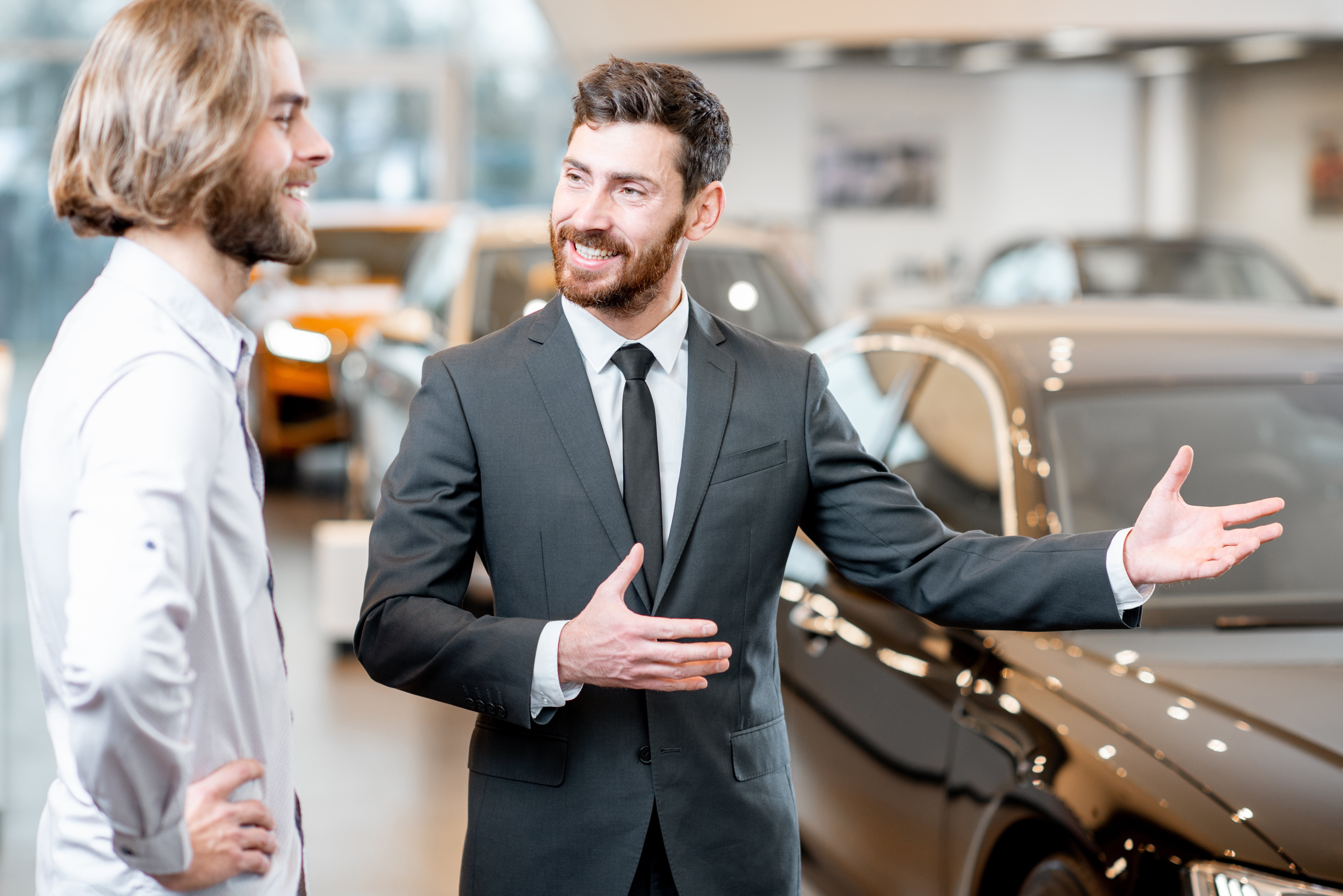salesperson-with-client-in-the-car-showroom-2021-12-09-02-00-08-utc