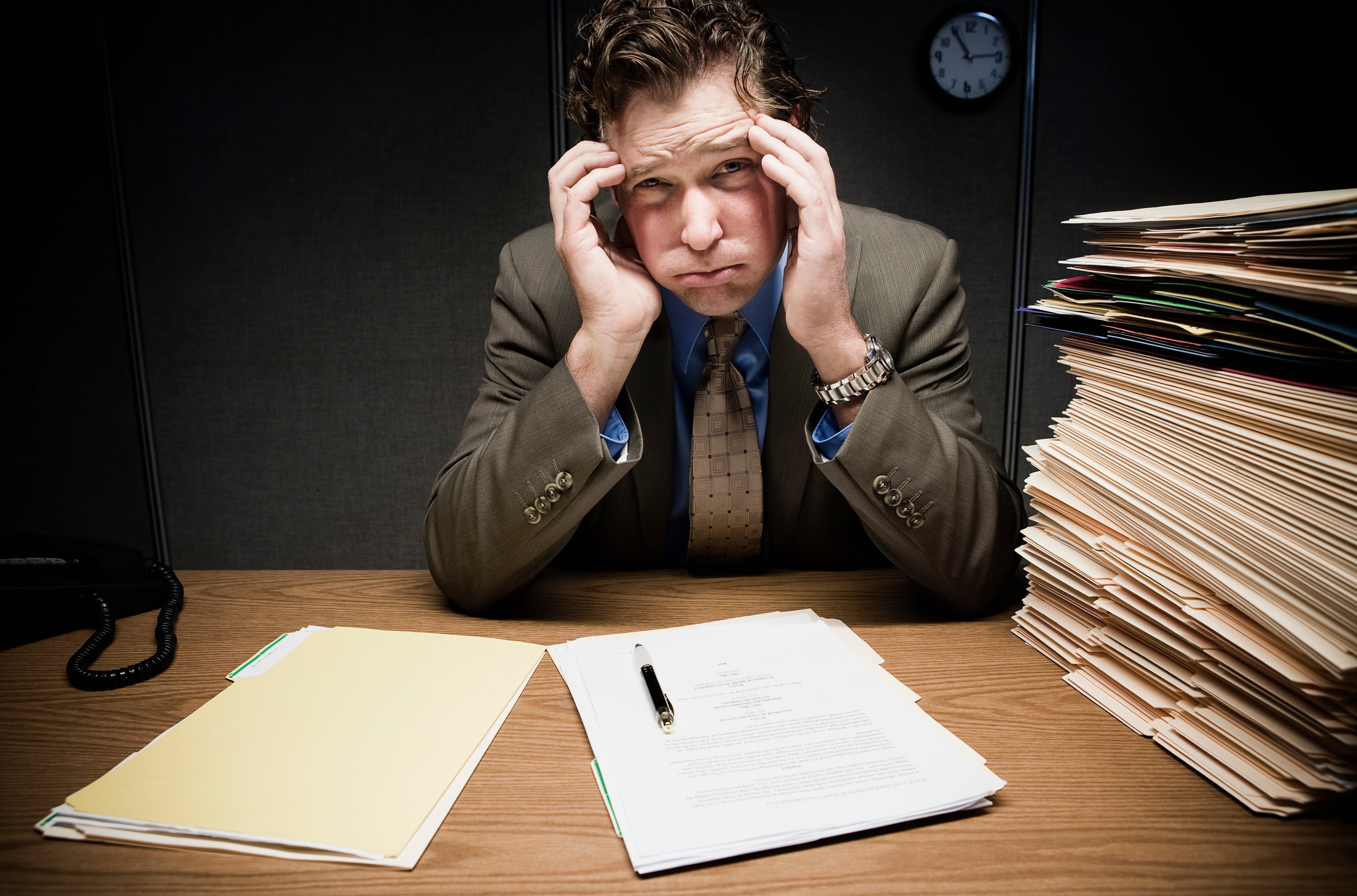 stressed-man-at-desk-with-paperwork-2022-03-04-01-54-31-utc (1)