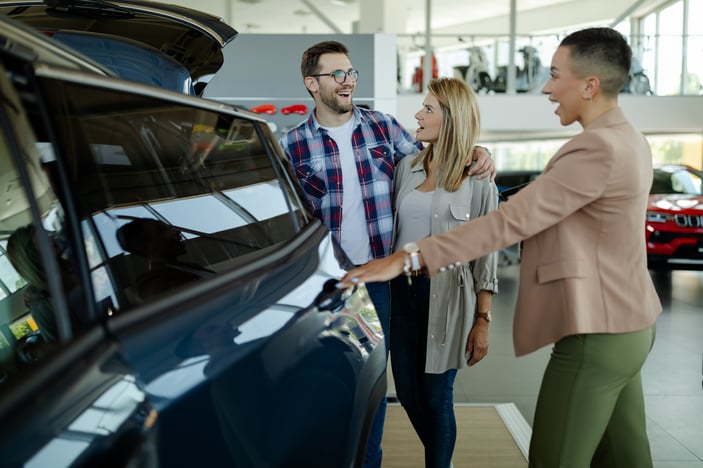 young-couple-with-car-agent-in-the-car-dealership-2021-09-03-14-44-17-utc