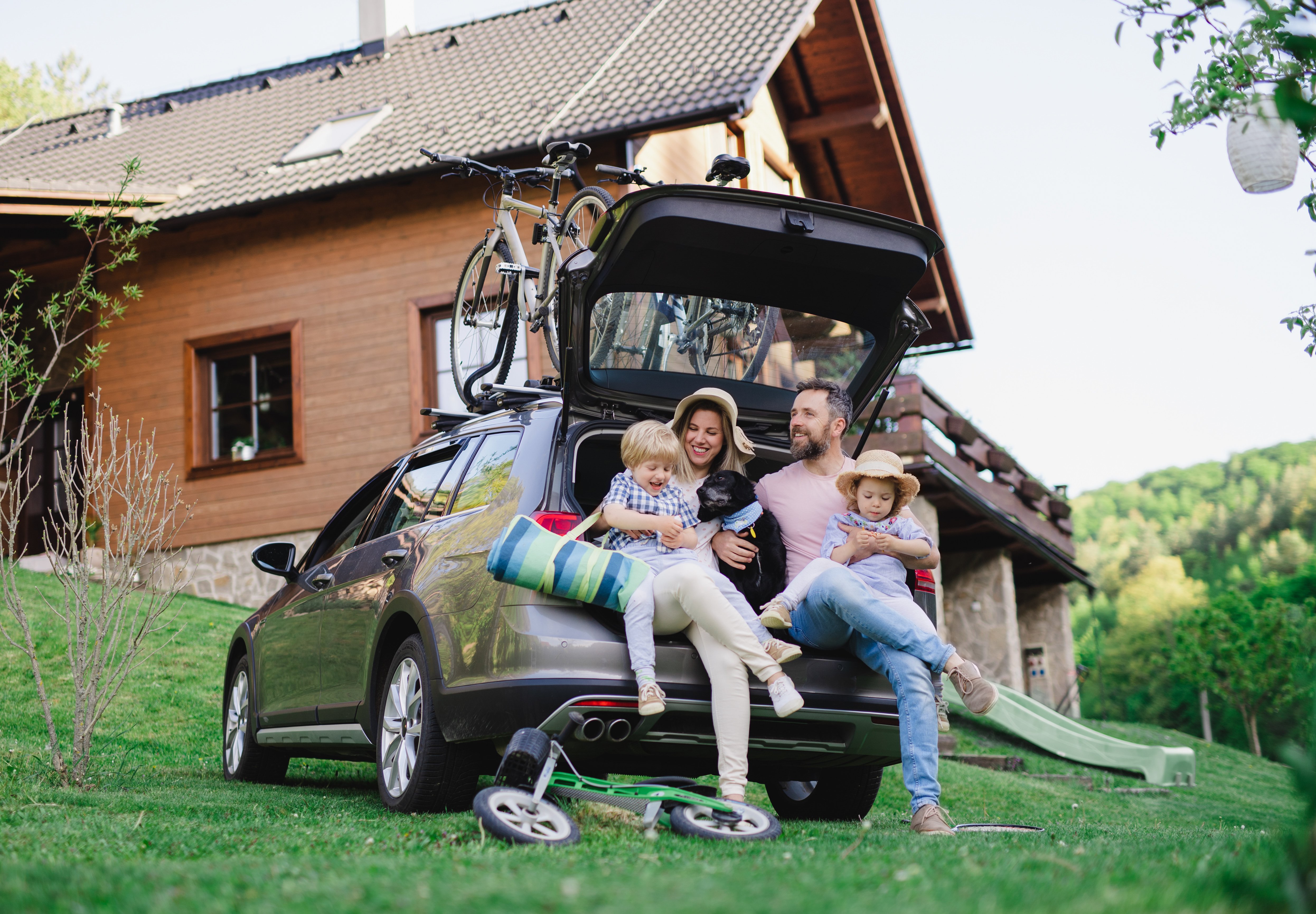 family with packed car and bikes