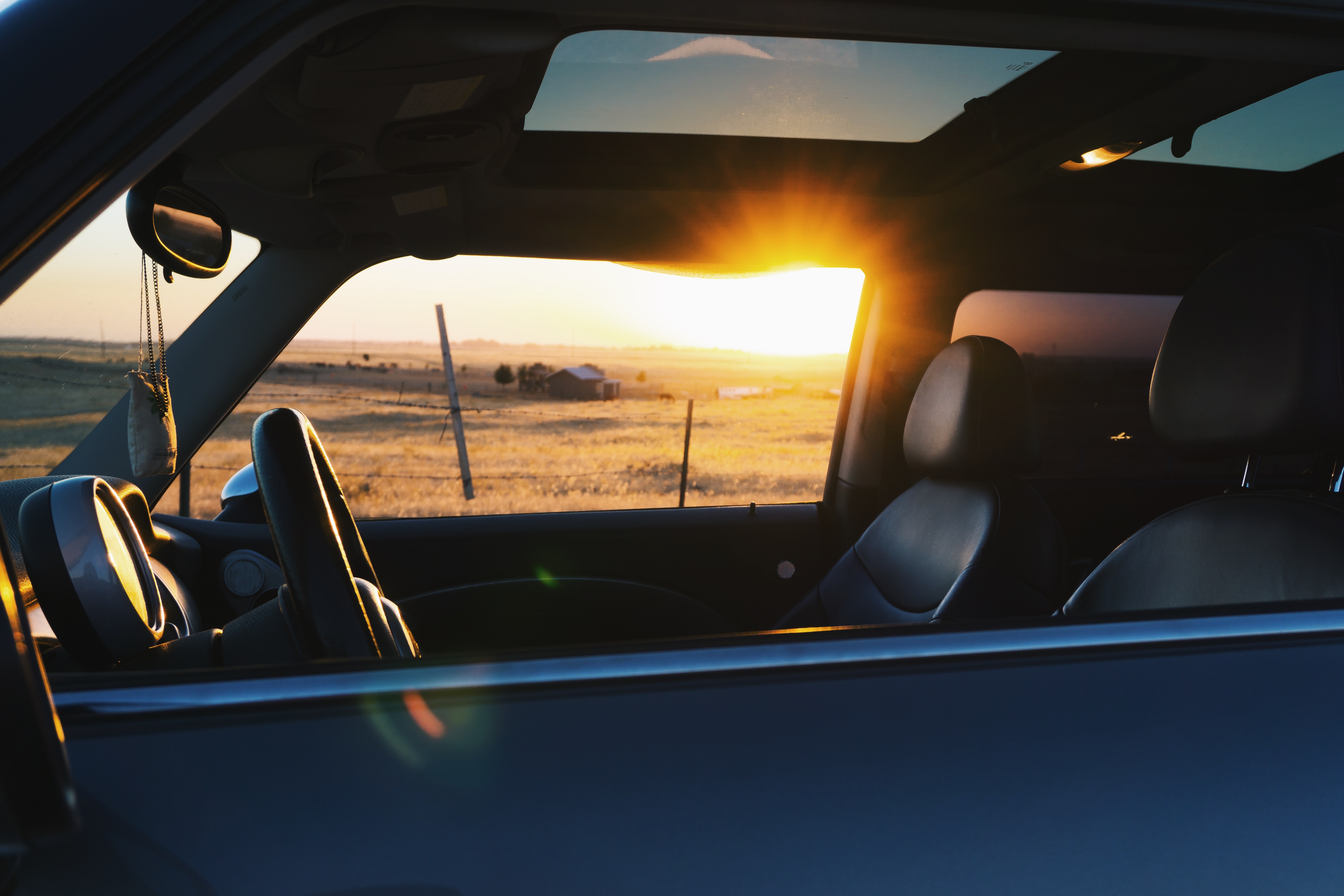 car with sunroof and sunset